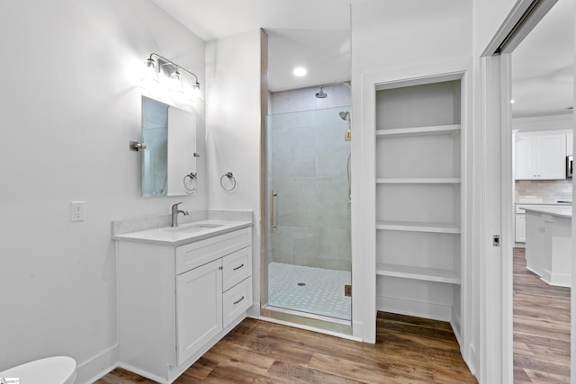 bathroom with tasteful backsplash, vanity, hardwood / wood-style floors, and walk in shower