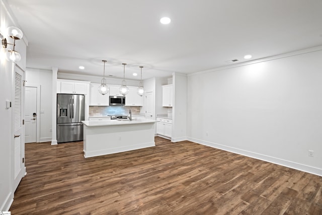 kitchen featuring pendant lighting, stainless steel appliances, an island with sink, and white cabinets