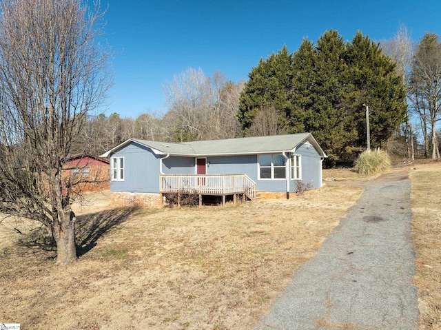 manufactured / mobile home with a deck and a front lawn