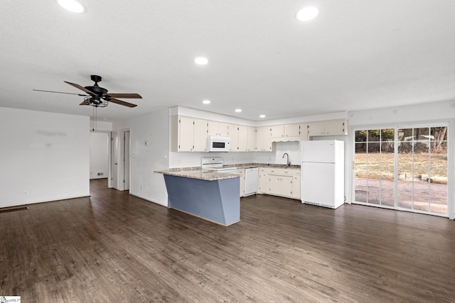 kitchen with sink, white cabinetry, light stone counters, dark hardwood / wood-style flooring, and white appliances