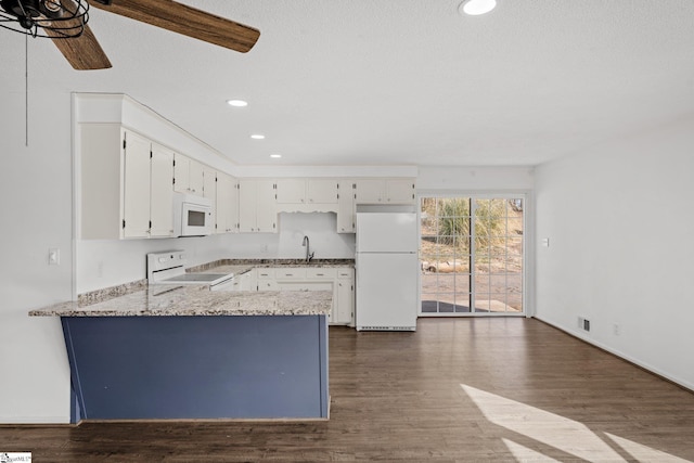 kitchen featuring dark hardwood / wood-style floors, sink, white cabinets, kitchen peninsula, and white appliances