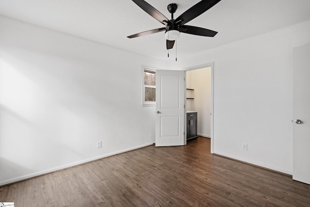 unfurnished bedroom featuring ceiling fan and dark hardwood / wood-style flooring