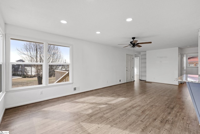 unfurnished living room with wood-type flooring and ceiling fan