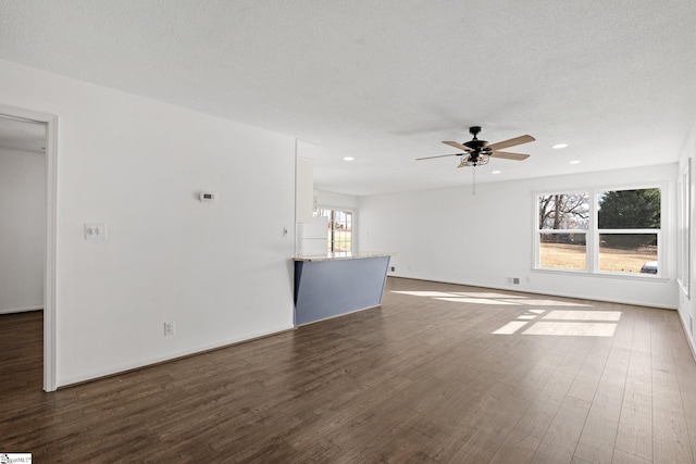 interior space featuring dark hardwood / wood-style flooring, ceiling fan, and a textured ceiling