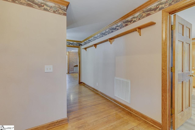 hall featuring ornamental molding and light hardwood / wood-style floors