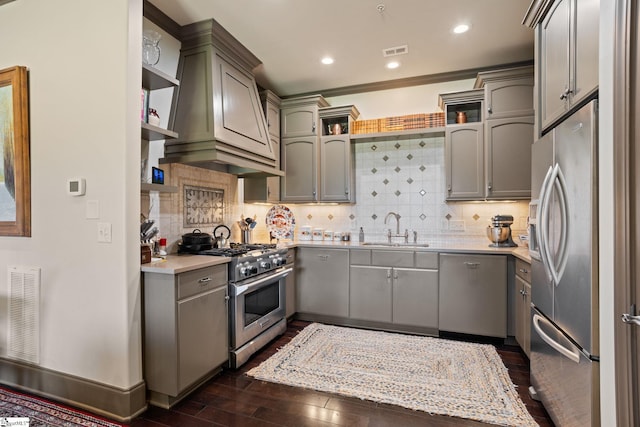 kitchen featuring dark wood-type flooring, sink, gray cabinetry, stainless steel appliances, and decorative backsplash