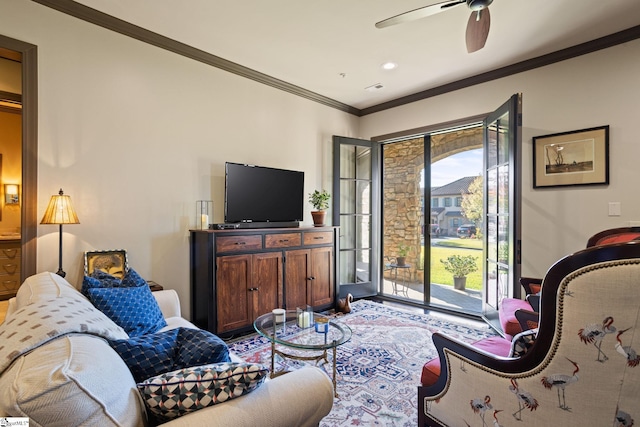 living room with ornamental molding and ceiling fan