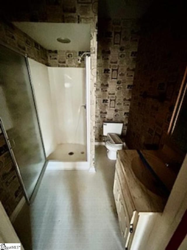 bathroom with toilet, a shower, and brick wall