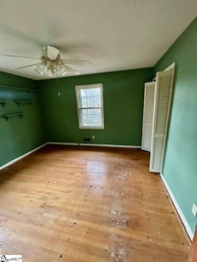 unfurnished bedroom with ceiling fan, a textured ceiling, and light wood-type flooring