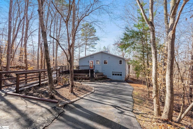 view of front facade featuring a garage and a wooden deck