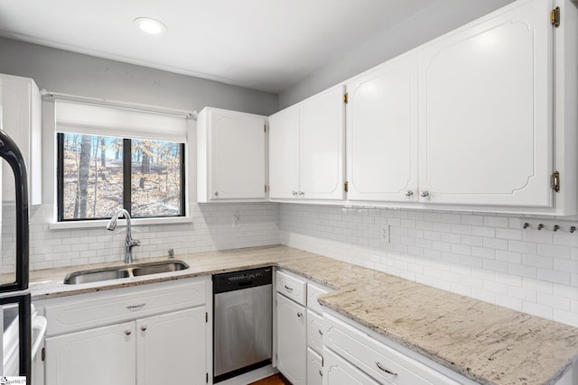 kitchen featuring white cabinetry, stainless steel dishwasher, light stone countertops, and sink