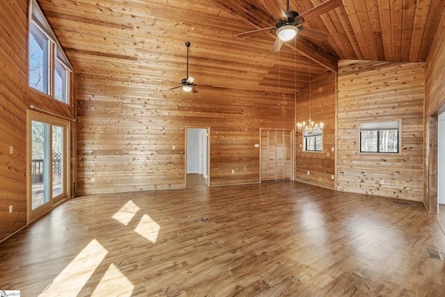 unfurnished living room with wooden walls, wooden ceiling, and wood-type flooring