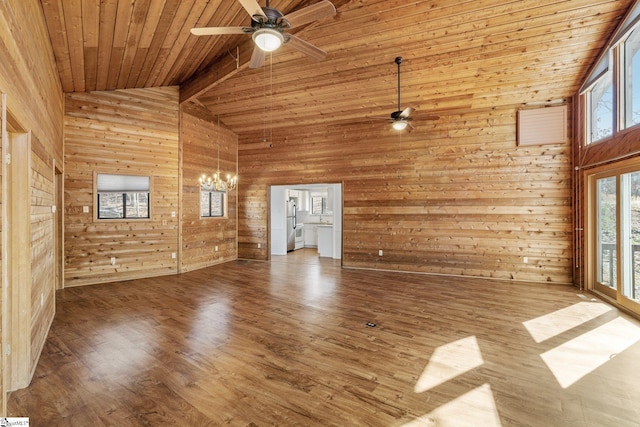 unfurnished living room with wood ceiling, hardwood / wood-style flooring, ceiling fan with notable chandelier, and wood walls