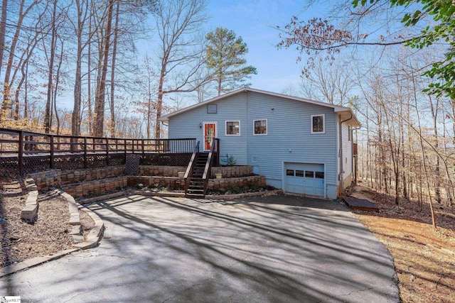 back of property featuring a wooden deck and a garage