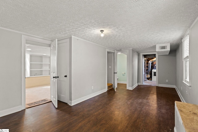 spare room featuring dark hardwood / wood-style floors and a textured ceiling