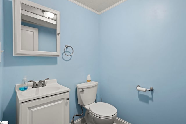 bathroom with ornamental molding, vanity, and toilet