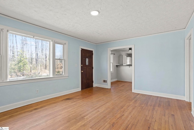 foyer entrance featuring light hardwood / wood-style floors and a textured ceiling