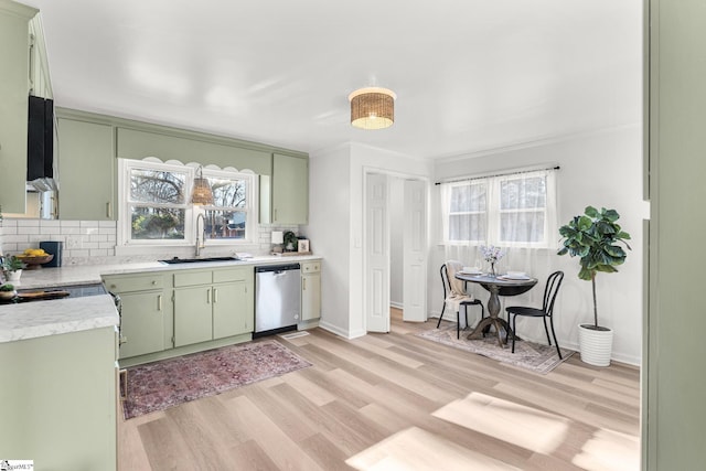 kitchen featuring green cabinets, sink, stainless steel dishwasher, and plenty of natural light