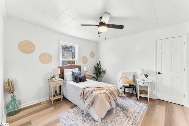 bedroom with hardwood / wood-style flooring, crown molding, and ceiling fan