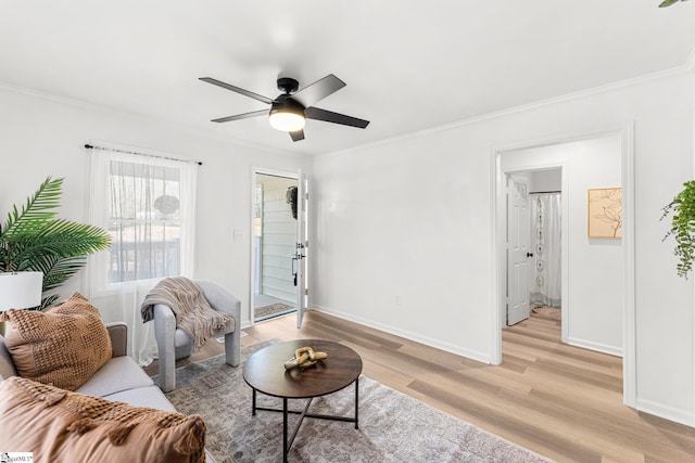 living room with ornamental molding, ceiling fan, and light wood-type flooring