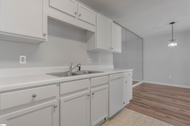 kitchen with pendant lighting, sink, dishwasher, a textured ceiling, and white cabinets