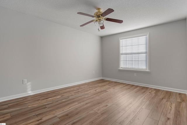 empty room with ceiling fan, a textured ceiling, and light hardwood / wood-style flooring