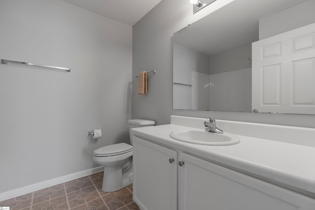 bathroom with vanity, tile patterned flooring, toilet, and walk in shower