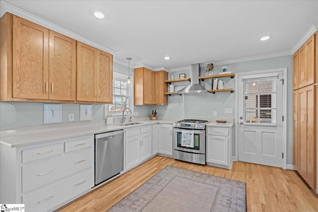 kitchen featuring sink, white cabinetry, decorative light fixtures, stainless steel appliances, and range hood