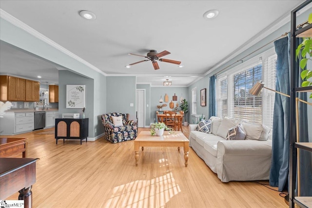 living room featuring sink, crown molding, light hardwood / wood-style flooring, and ceiling fan