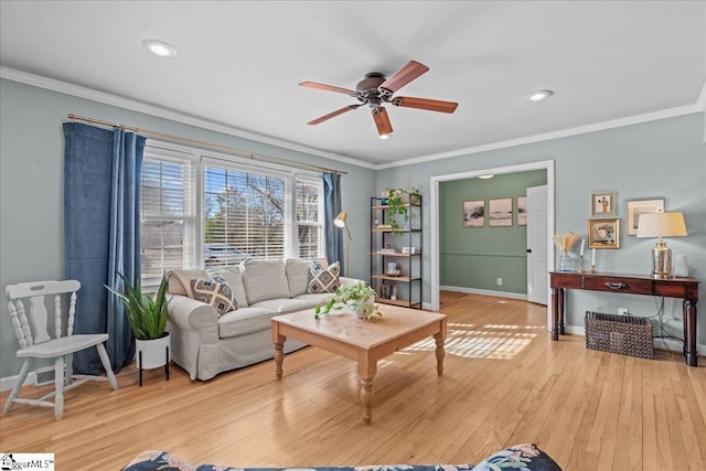 living room featuring ceiling fan, ornamental molding, and light wood-type flooring