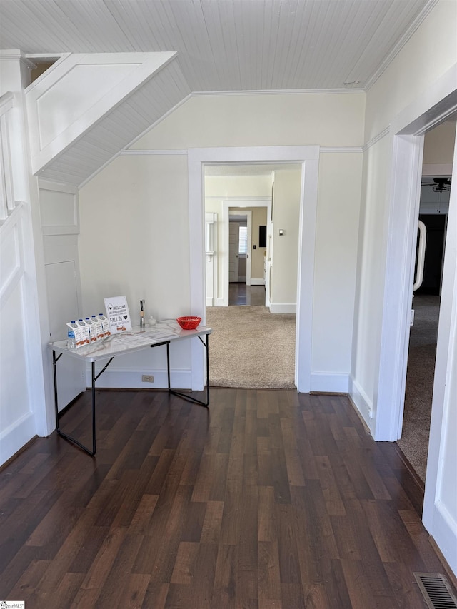 corridor with vaulted ceiling and dark hardwood / wood-style floors