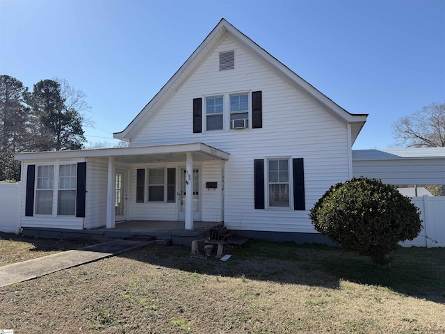 bungalow-style home featuring cooling unit, a porch, and a front lawn