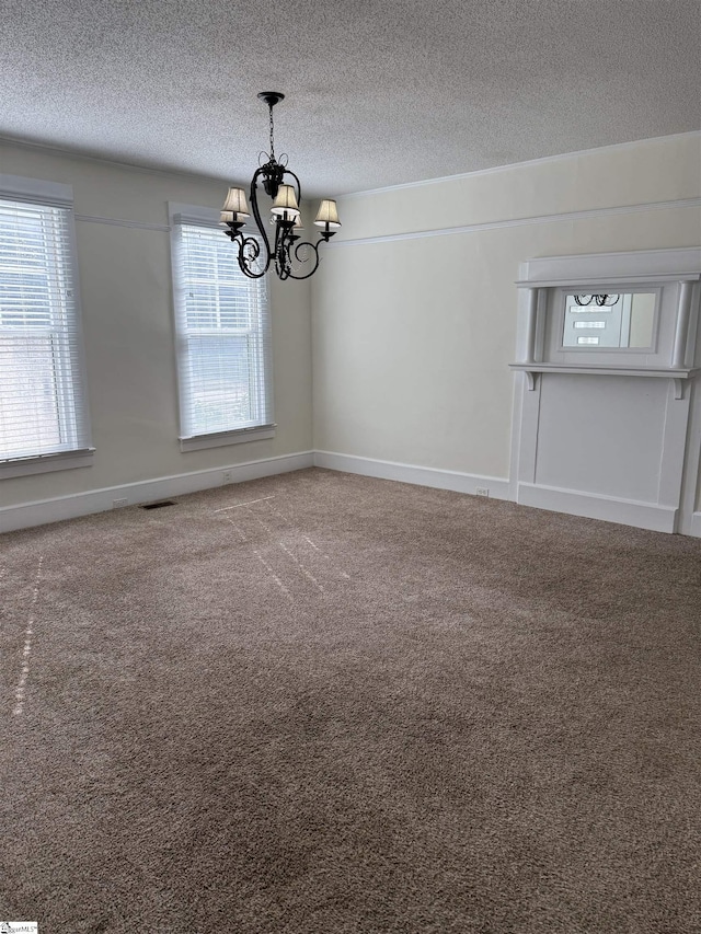 interior space with an inviting chandelier, carpet flooring, and a textured ceiling