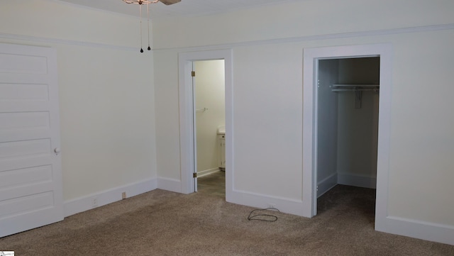 unfurnished bedroom with a walk in closet, carpet floors, and a closet