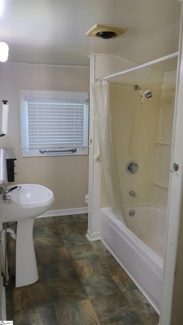 bathroom with shower / tub combo and toilet