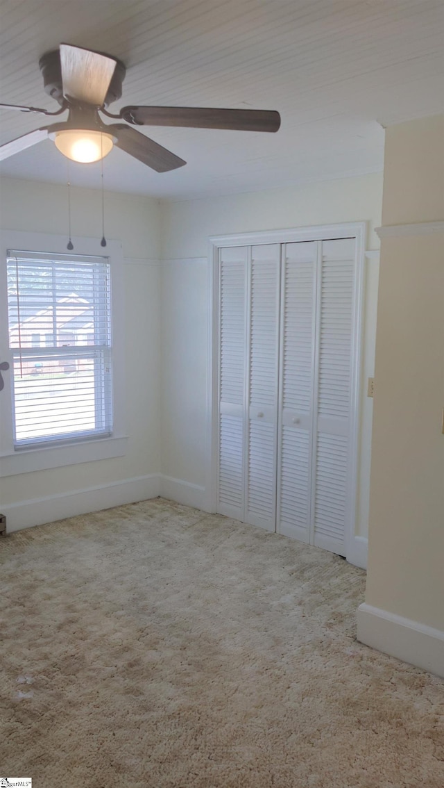 unfurnished bedroom featuring carpet, ceiling fan, and a closet