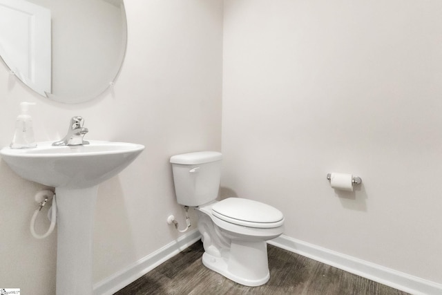 bathroom with wood-type flooring and toilet