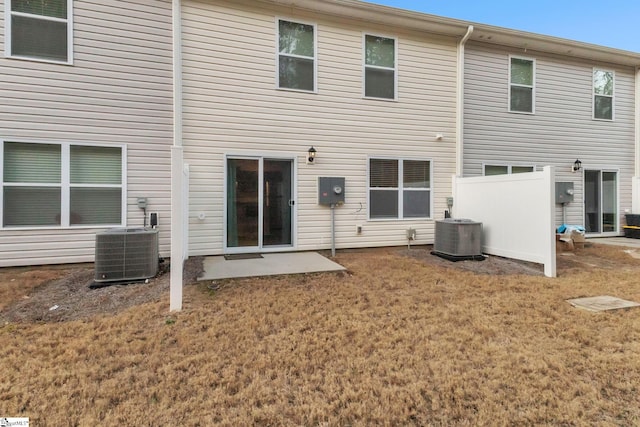 back of house with central AC and a lawn