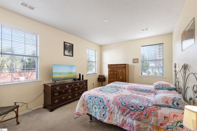 carpeted bedroom featuring multiple windows and a textured ceiling