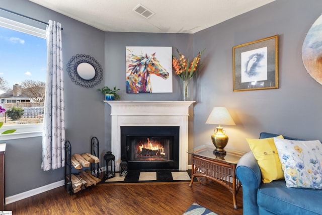 living area with plenty of natural light and hardwood / wood-style floors