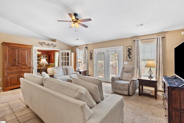 carpeted living room with french doors, a healthy amount of sunlight, lofted ceiling, and ceiling fan