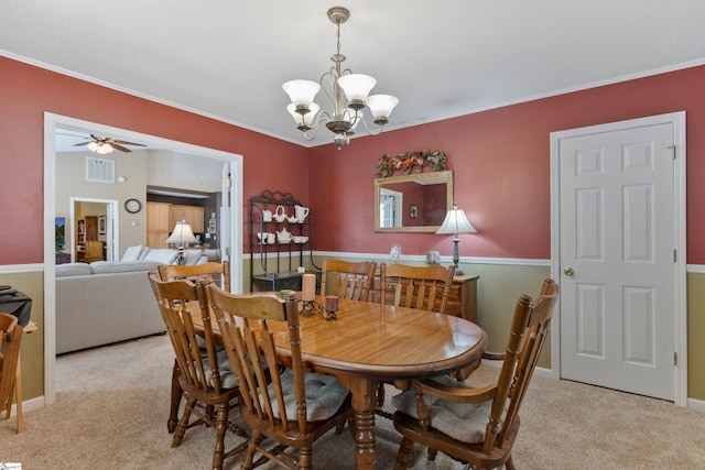 carpeted dining area with crown molding and ceiling fan with notable chandelier