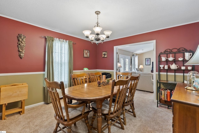 carpeted dining area with crown molding and a chandelier