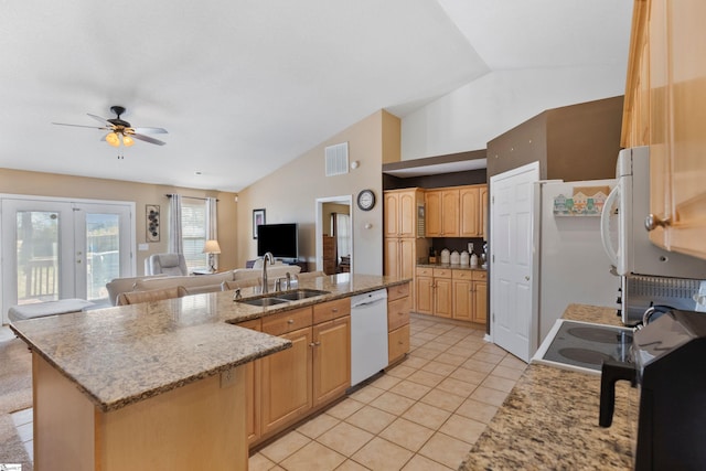 kitchen with light brown cabinetry, sink, vaulted ceiling, dishwasher, and an island with sink