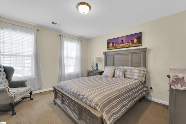 bedroom with multiple windows and light carpet