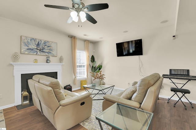 living room with dark hardwood / wood-style flooring and ceiling fan