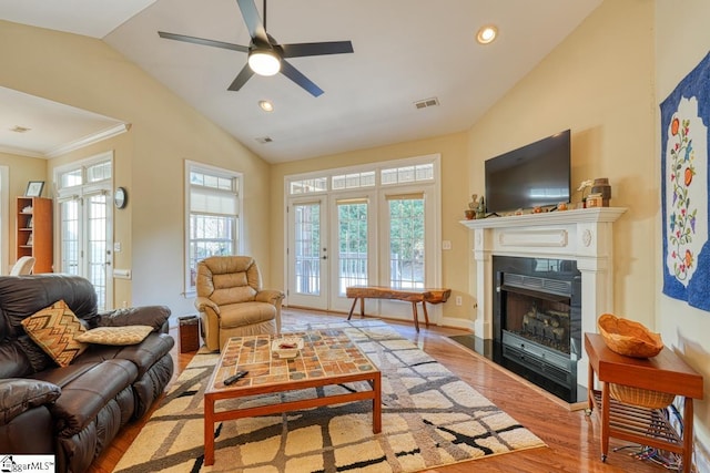 living room with vaulted ceiling, ceiling fan, and light wood-type flooring