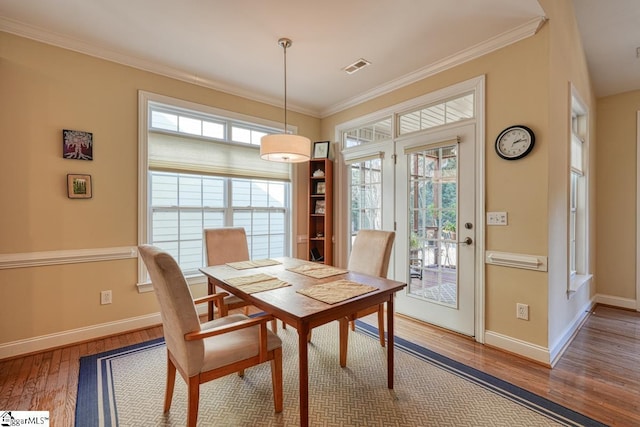 dining space featuring hardwood / wood-style flooring and ornamental molding