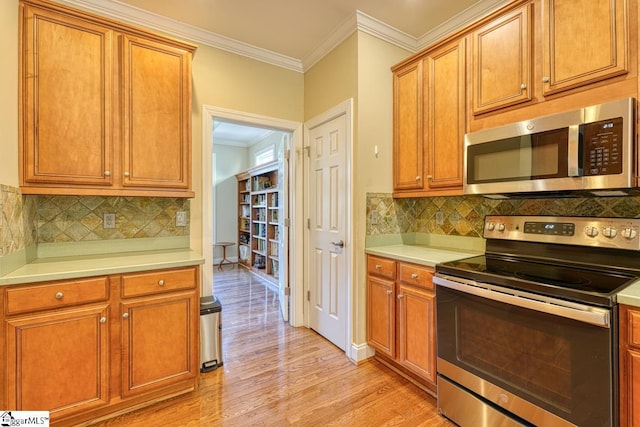 kitchen with decorative backsplash, ornamental molding, light hardwood / wood-style floors, and appliances with stainless steel finishes