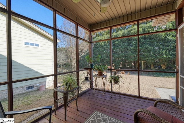 unfurnished sunroom featuring wood ceiling, a wealth of natural light, and ceiling fan